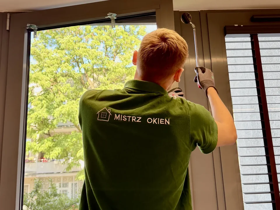 Serwisant Mistrz Okien pracuje przy mechanizmie otwartego okna
