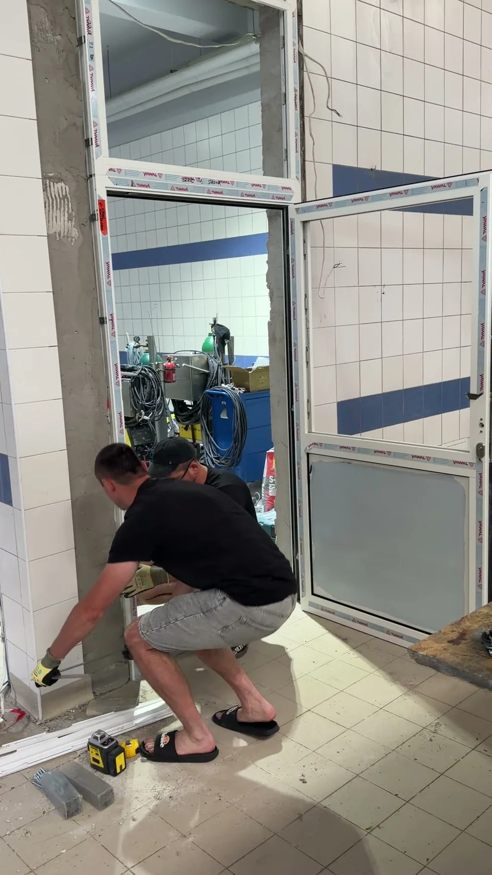 Prace montażowe przy dolnej części drzwi aluminiowych w obiekcie Lubaszka