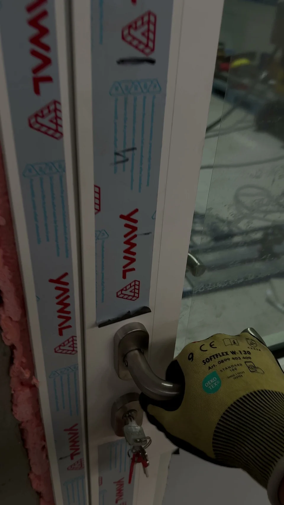 Dłoń montera sprawdzającego klamkę zamontowanych drzwi aluminiowych YAWAL